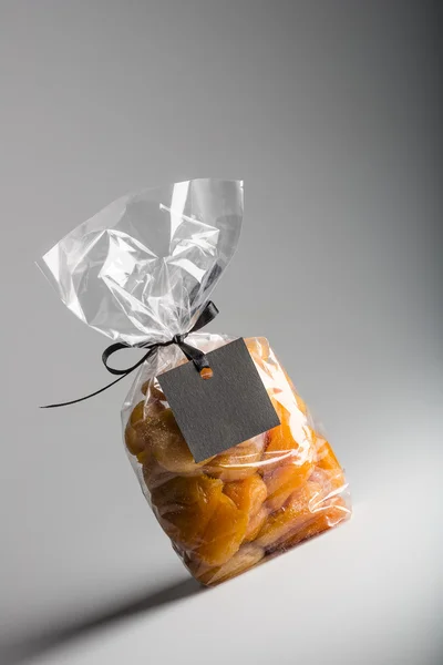 Bag of apricots with black blank label and copy space — Stock Photo, Image