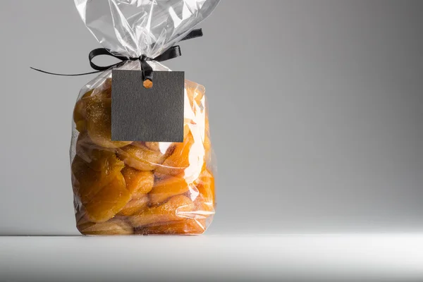 Plastic bag of apricots with blank label and copy space — Stock Photo, Image