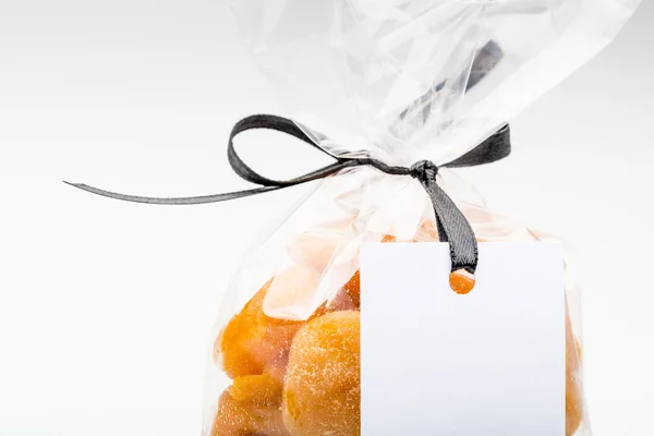 Closeup on plastic bag of dried apricots with blank label — Stock Photo, Image