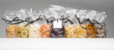 Mixed dried fruits collection into elegant plastic bags clipart