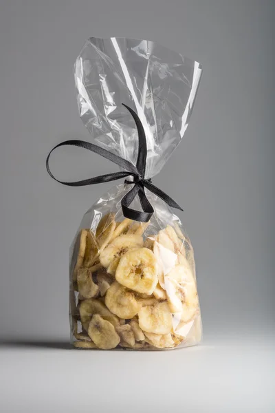 Sac de luxe de chips de banane séchées isolées sur fond gris . — Photo