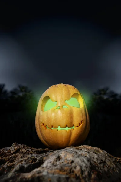 Halloween pumpkin in on a rock in the darkness — Stock Photo, Image