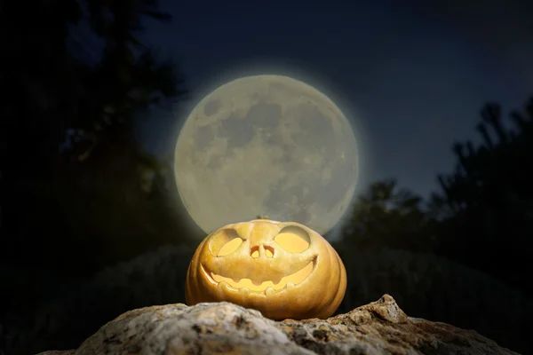 Spooky Halloween pumpkin in moon light on a rock — Stock Photo, Image