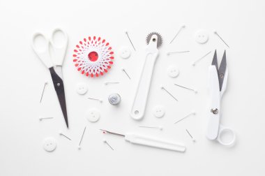 Beyaz üzerinde dağınık dikiş araçları