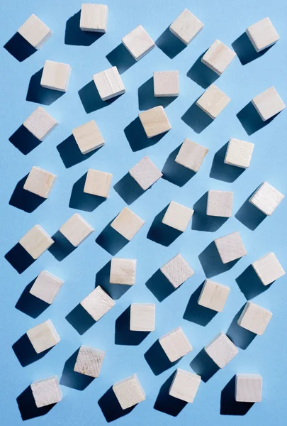 Wooden cubes spread over blue — Stock Photo, Image