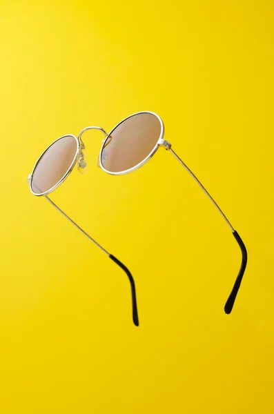 Sarı üzerinde yuvarlak güneş gözlüğü — Stok fotoğraf