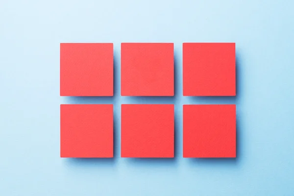 Паперові квадрати організовані над синім — стокове фото