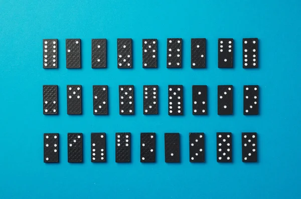 Domino kousky dobře organizované přes modré — Stock fotografie