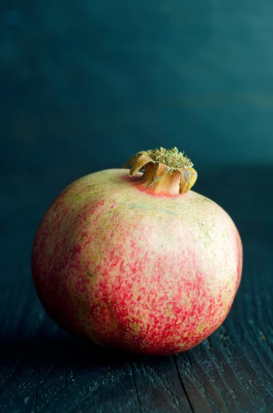 Pomegranate over dark wooden — Stock Photo, Image