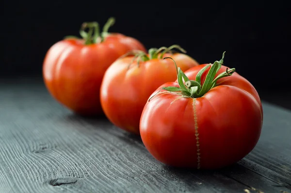 Biologische tomaten boven houten tafel — Stockfoto