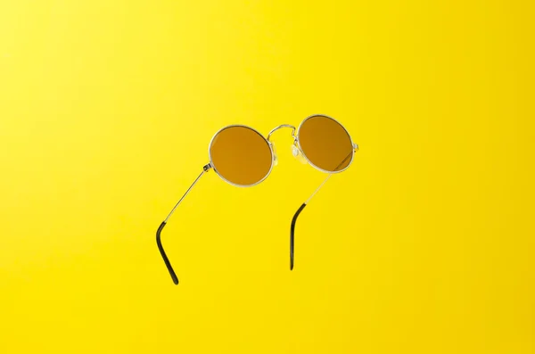 Στρογγυλά γυαλιά ηλίου πάνω από το κίτρινο — Φωτογραφία Αρχείου