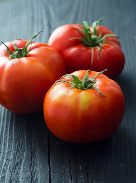 Biologische tomaten boven houten tafel — Stockfoto