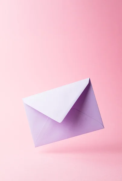 Envelope roxo caiu sobre rosa — Fotografia de Stock