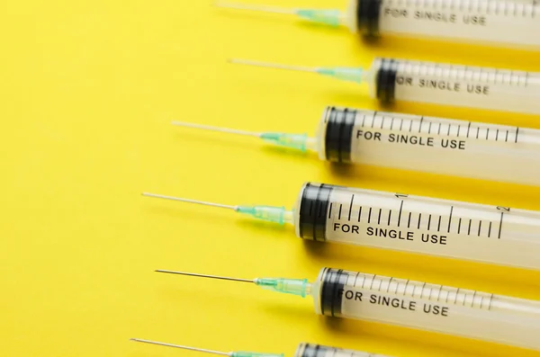 Details of syringes over bright yellow — Stock Photo, Image