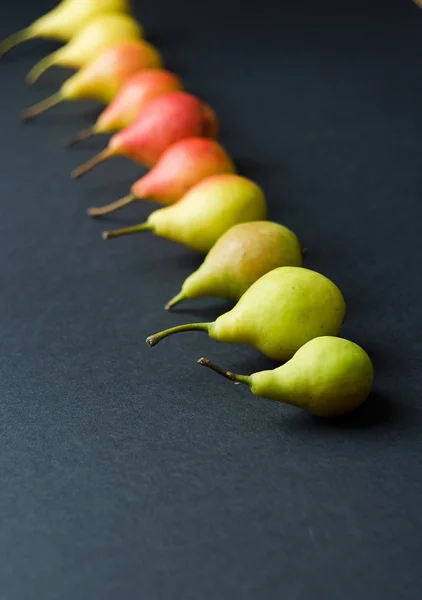 Colorful pears organized in a row — Stock Photo, Image