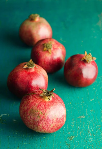 Pomegranates over grunge green — Stock Photo, Image