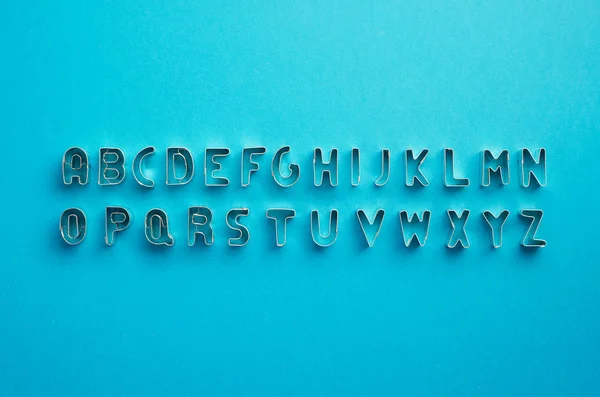 Letras do alfabeto organizadas sobre azul — Fotografia de Stock