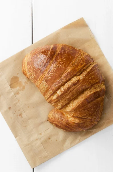 Croissant-t, mint a barna papír — Stock Fotó