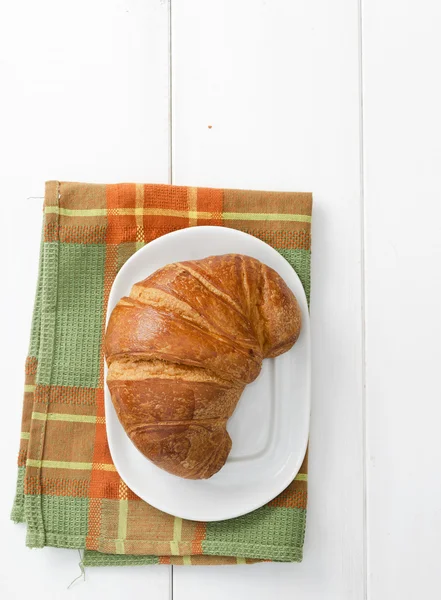 Croissant sobre pano verde — Fotografia de Stock