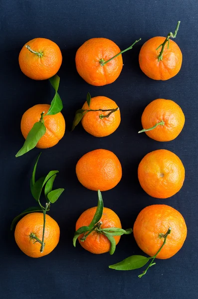 Tangerines over dark blue cloth — Stock Photo, Image