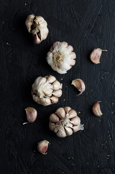 Cloves of garlic over sawdust table — Stock Photo, Image