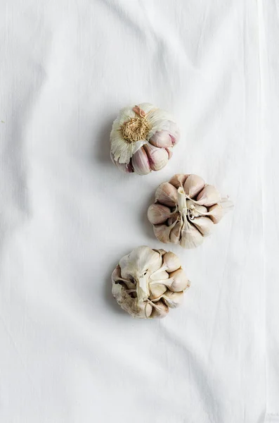 Cloves of garlic over white cloth — Stock Photo, Image