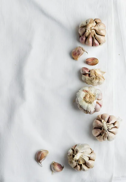 Cloves of garlic over white cloth — Stock Photo, Image