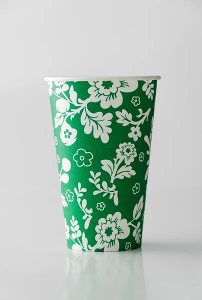 Green paper cup with flowers pattern — Stock Photo, Image