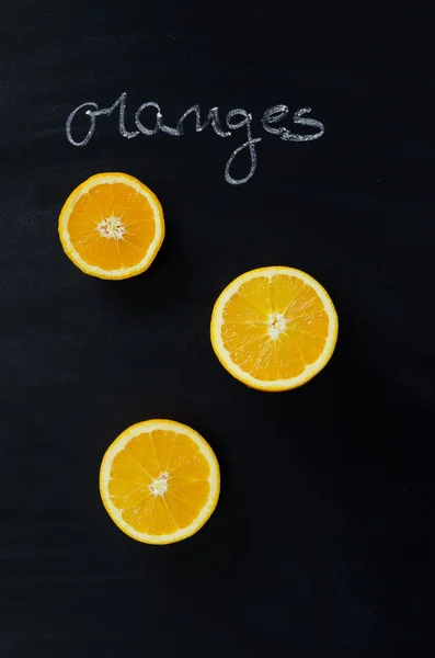 Orange fruits and handwritten word "oranges" — Stock Photo, Image