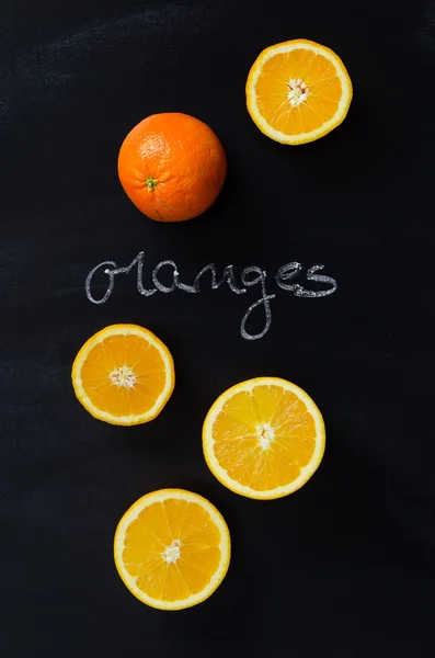 Orange fruits and handwritten word "oranges" — Stock Photo, Image