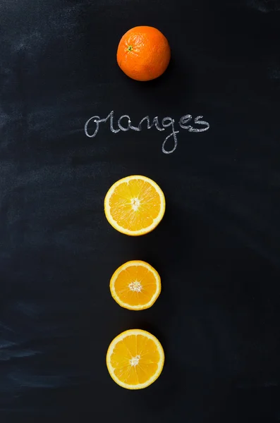 Orange fruits and handwritten word "oranges" — Stock Photo, Image