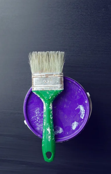 Used paintbrush over a paint bucket — Stock Photo, Image