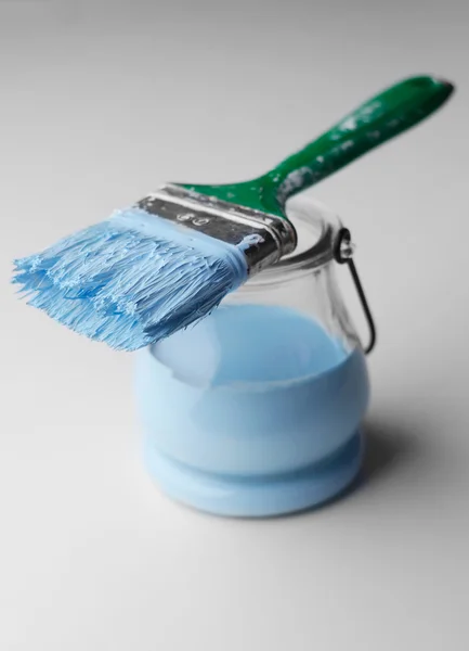 Paintbrush and a jar with blue paint — Stock Photo, Image