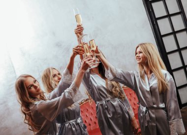 Güzel genç kadınlar evde pijama partisinde şarap içiyorlar.