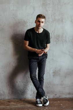 Happy, handsome man on a concrete wall background