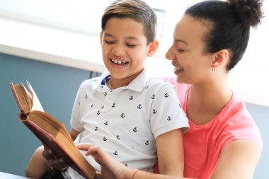 Anne oğluna bir kitap okuyor.