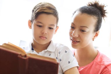 Anne oğluna bir kitap okuyor.