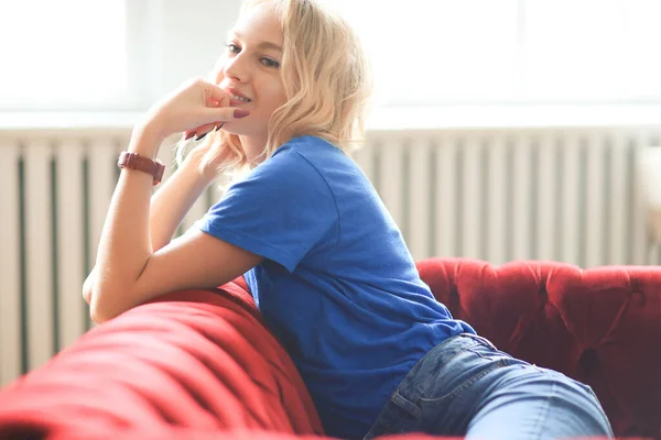 Junges Mädchen Auf Einem Roten Sofa — Stockfoto