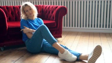 Odadaki rahat koltukta dinlenen genç bir kadın.