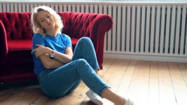 Odadaki rahat koltukta dinlenen genç bir kadın.