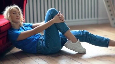 Odadaki rahat koltukta dinlenen genç bir kadın.