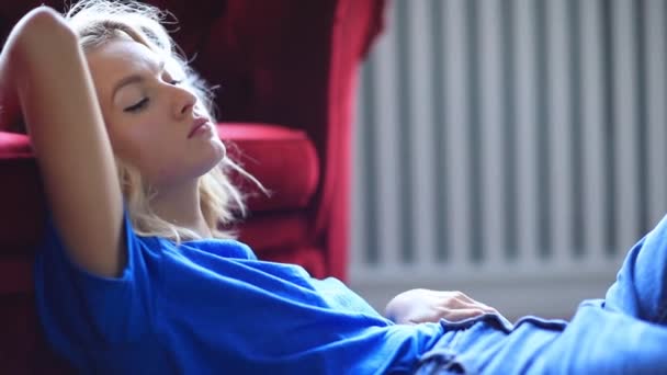 年轻女子在房间里舒适的沙发上休息 — 图库视频影像