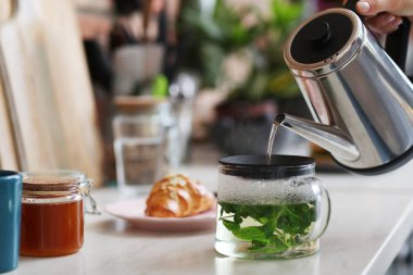 - Eve. Mutfakta çay yapan kadın.