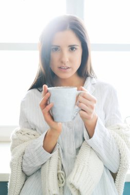 Beyaz kazaklı kadın evde.