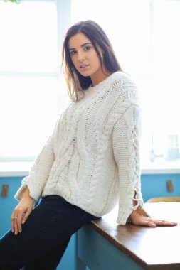 Beyaz kazaklı kadın evde.