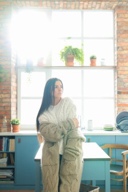 Beyaz kazaklı kadın evde.