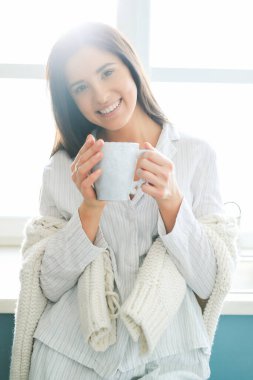 Beyaz kazaklı kadın evde.