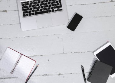 Tahta masadaki boş ekranlı dizüstü bilgisayar ve tabletin üst görünümü