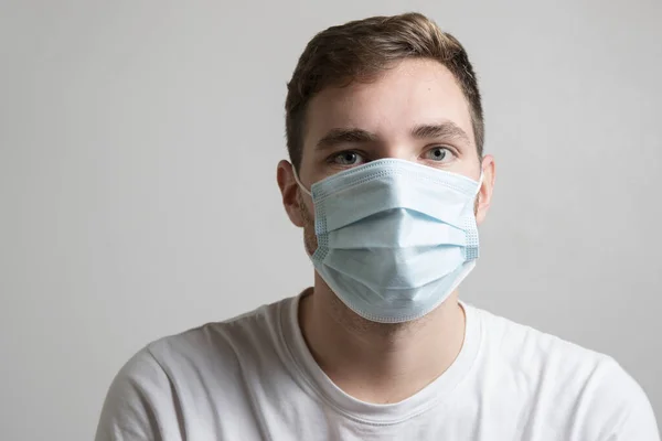 Kameraya ya da önüne bakan virüs ve bakterilerden kendini korumak için maske takan çocuk.