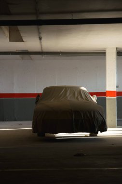 Eski bir koleksiyon arabası karanlık bir garajda korunuyor. Otomobil konsepti, atölye.